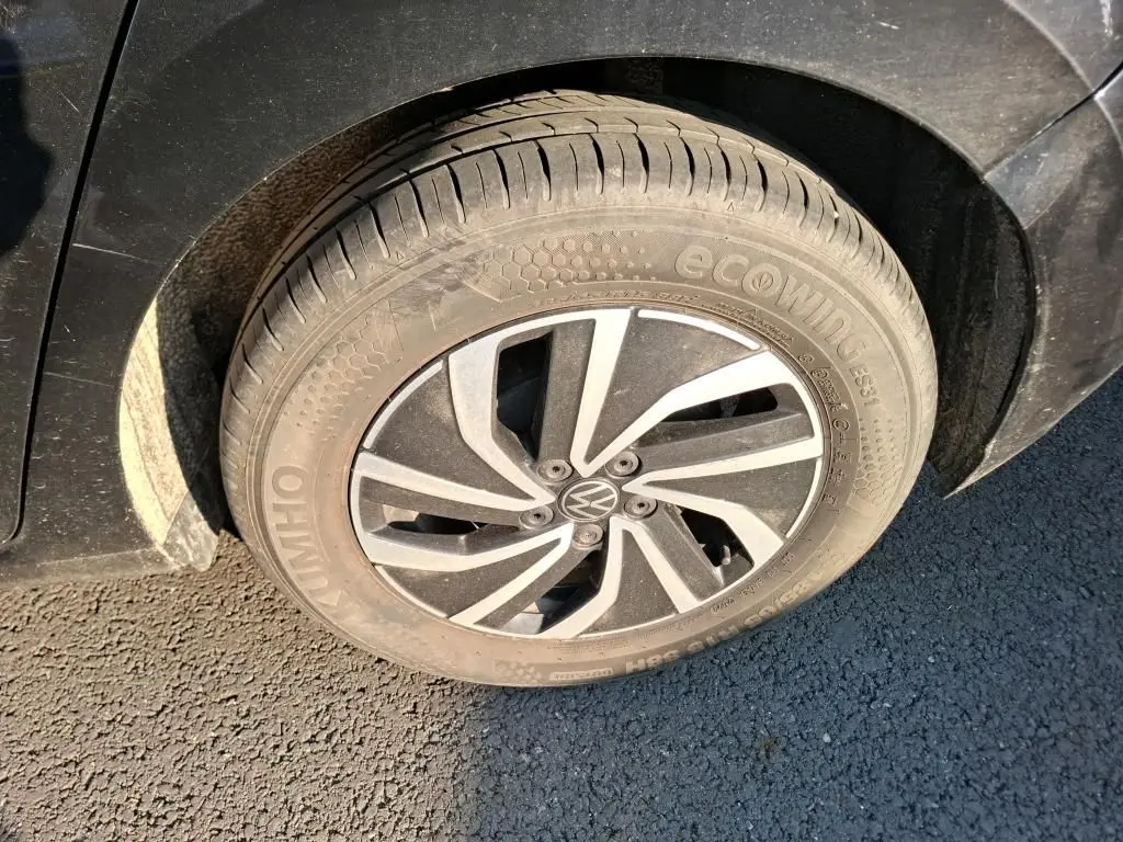 Gros plan sur la roue avant gauche noire d’une Volkswagen Polo 1.0 TSI 95 DSG7 Life avec jante alliage au design moderne.