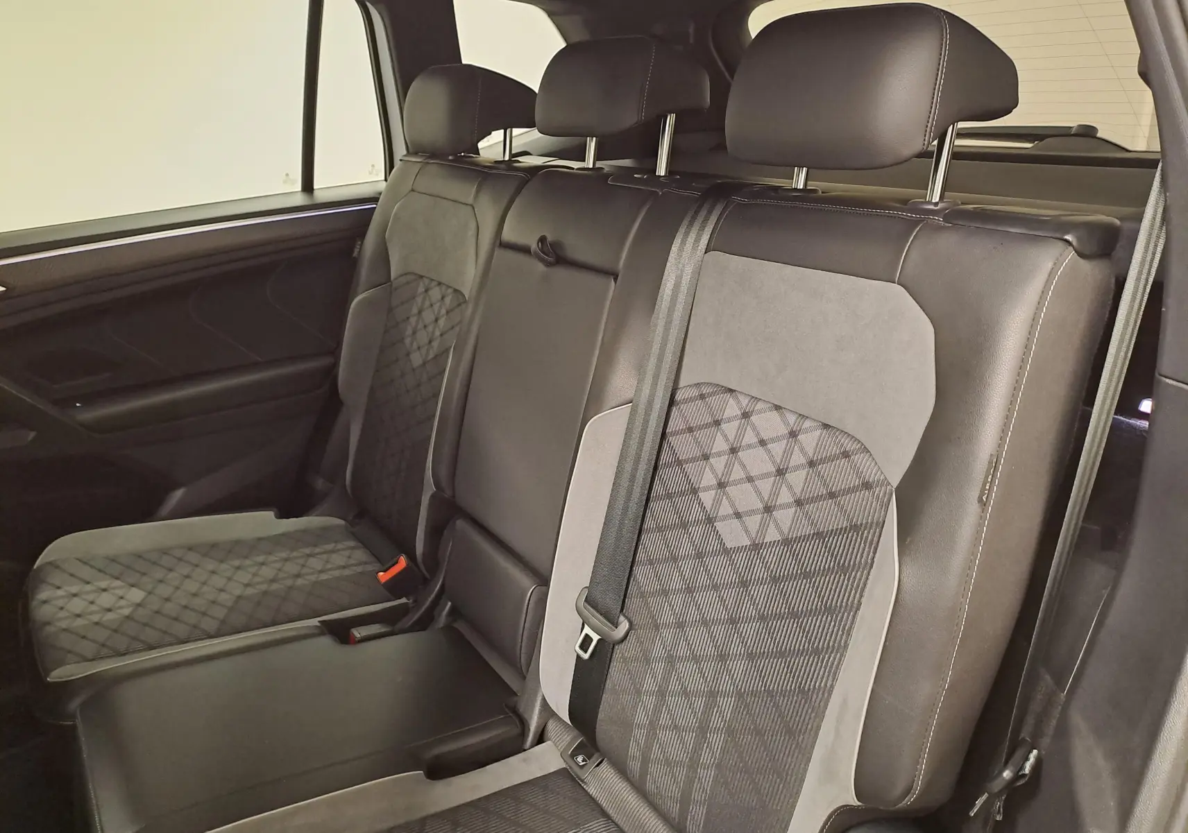 Vue intérieure côté droit des sièges arrière en cuir noir et tissu gris à motifs du Volkswagen Tiguan Allspace 2023 R-Line.