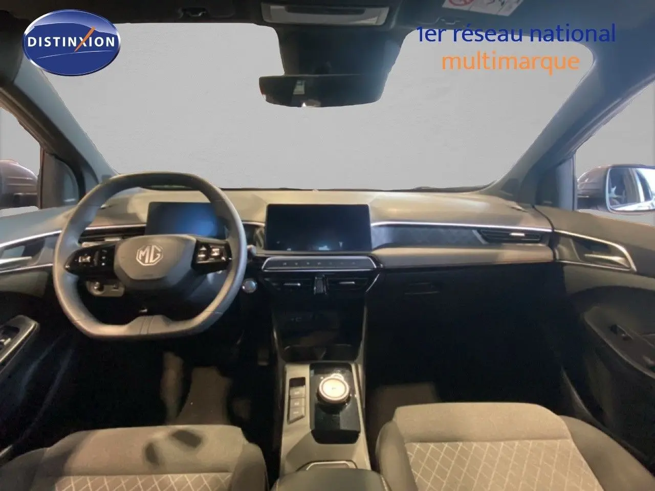 Intérieur de la MG3 1.5 Hybrid 2024 en vue frontale, tableau de bord moderne avec écran tactile et volant multifonction noir.