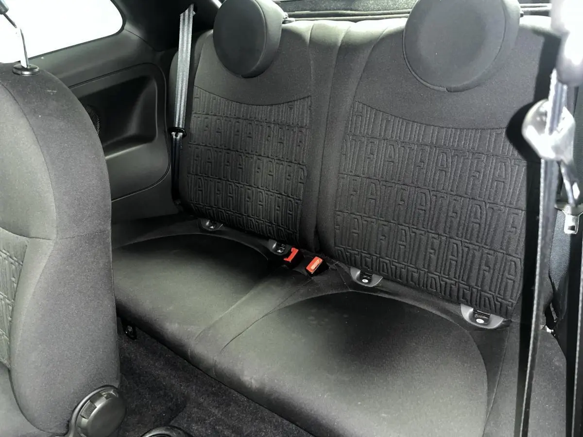 Vue rapprochée de la banquette arrière noire avec monogramme FIAT en tissu dans une Fiat 500 gris 2023.