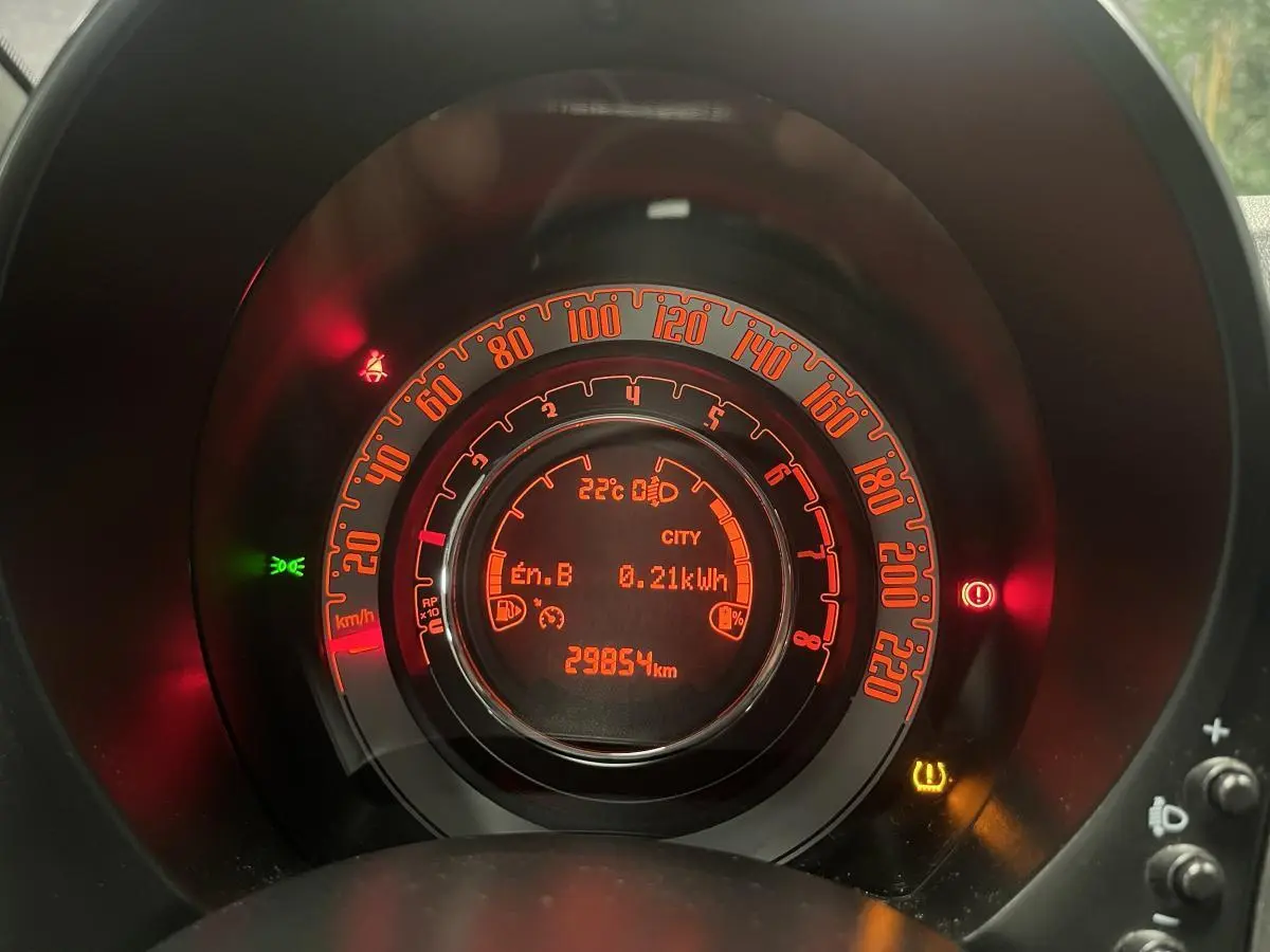 Gros plan sur le combiné d'instrumentation orange de la Fiat 500 gris, affichant 29854 km et mode City activé.