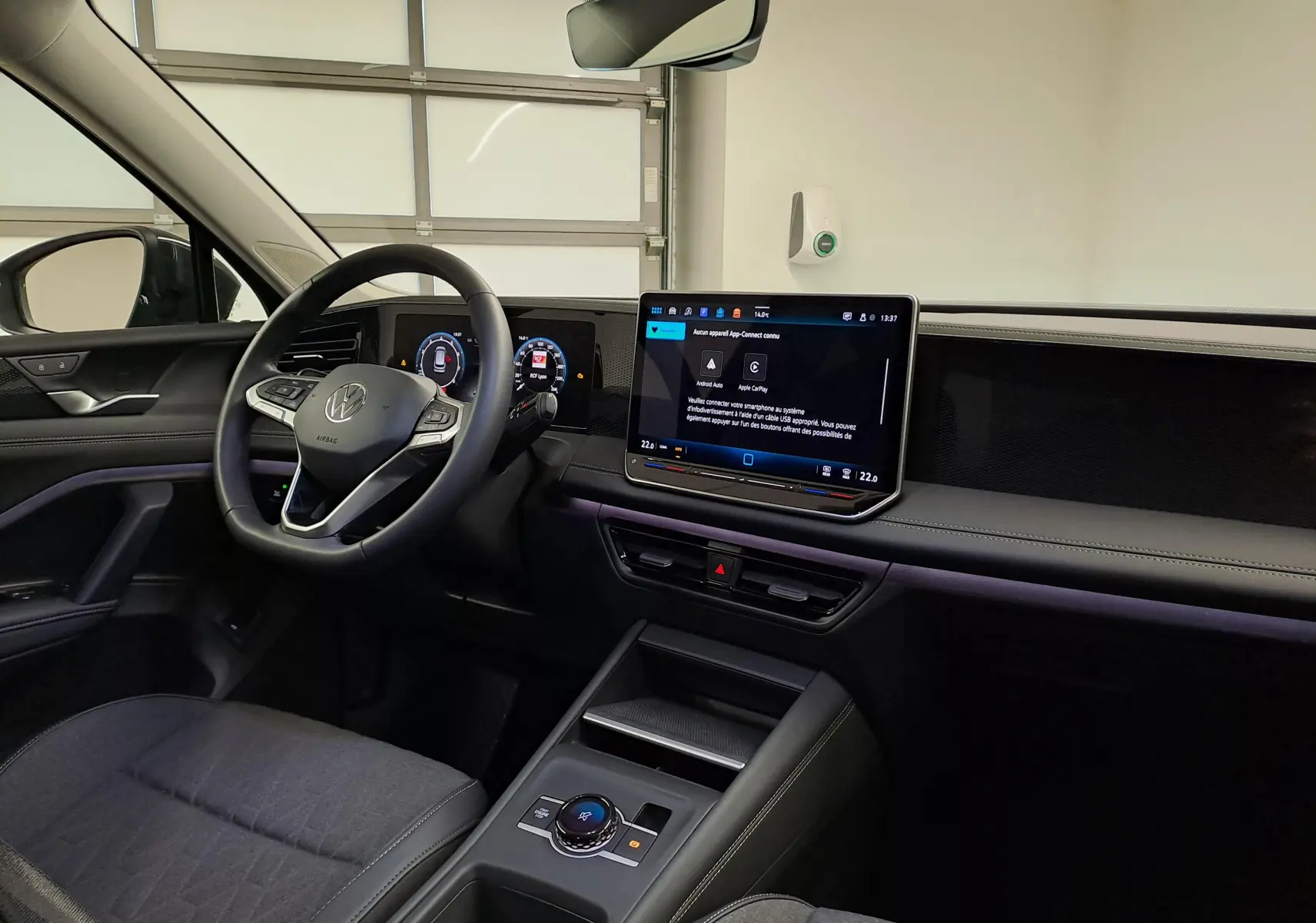 Vue intérieure côté conducteur du Volkswagen Tiguan 2024, tableau de bord moderne avec écran tactile et volant multifonction.