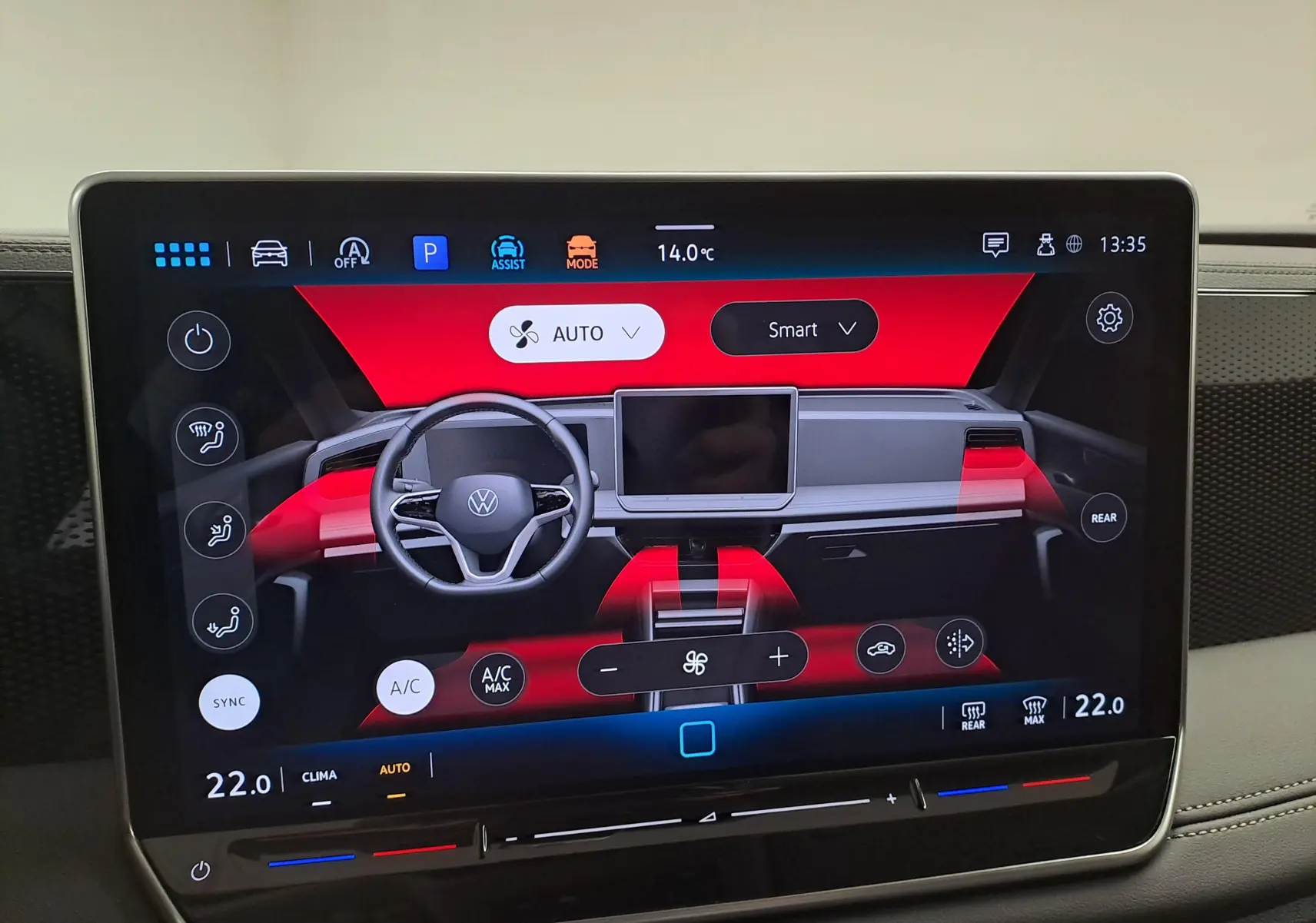 Écran tactile intérieur du Volkswagen Tiguan 2024 affichant le tableau de bord digital avec commandes de climatisation et assistant de stationnement.