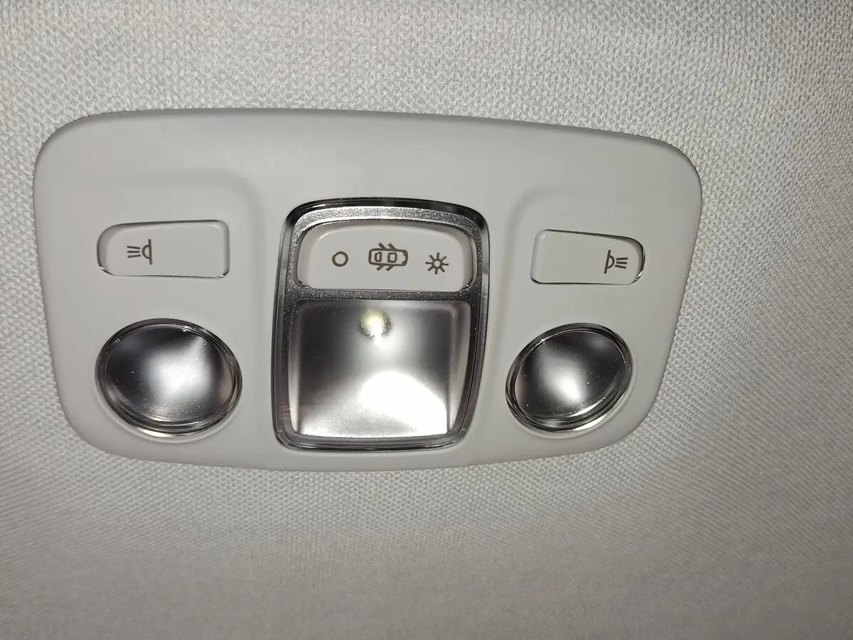 Plafonnier intérieur gris clair avec boutons d'éclairage et lampes de lecture ronds dans une Citroën C5 hybride 2025.