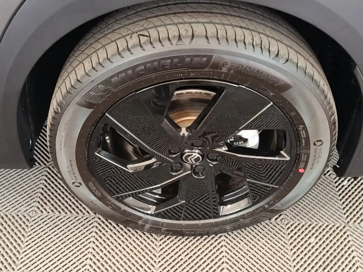 Gros plan sur la roue avant droite noire brillante avec logo Citroën et pneu Michelin e.Primacy.