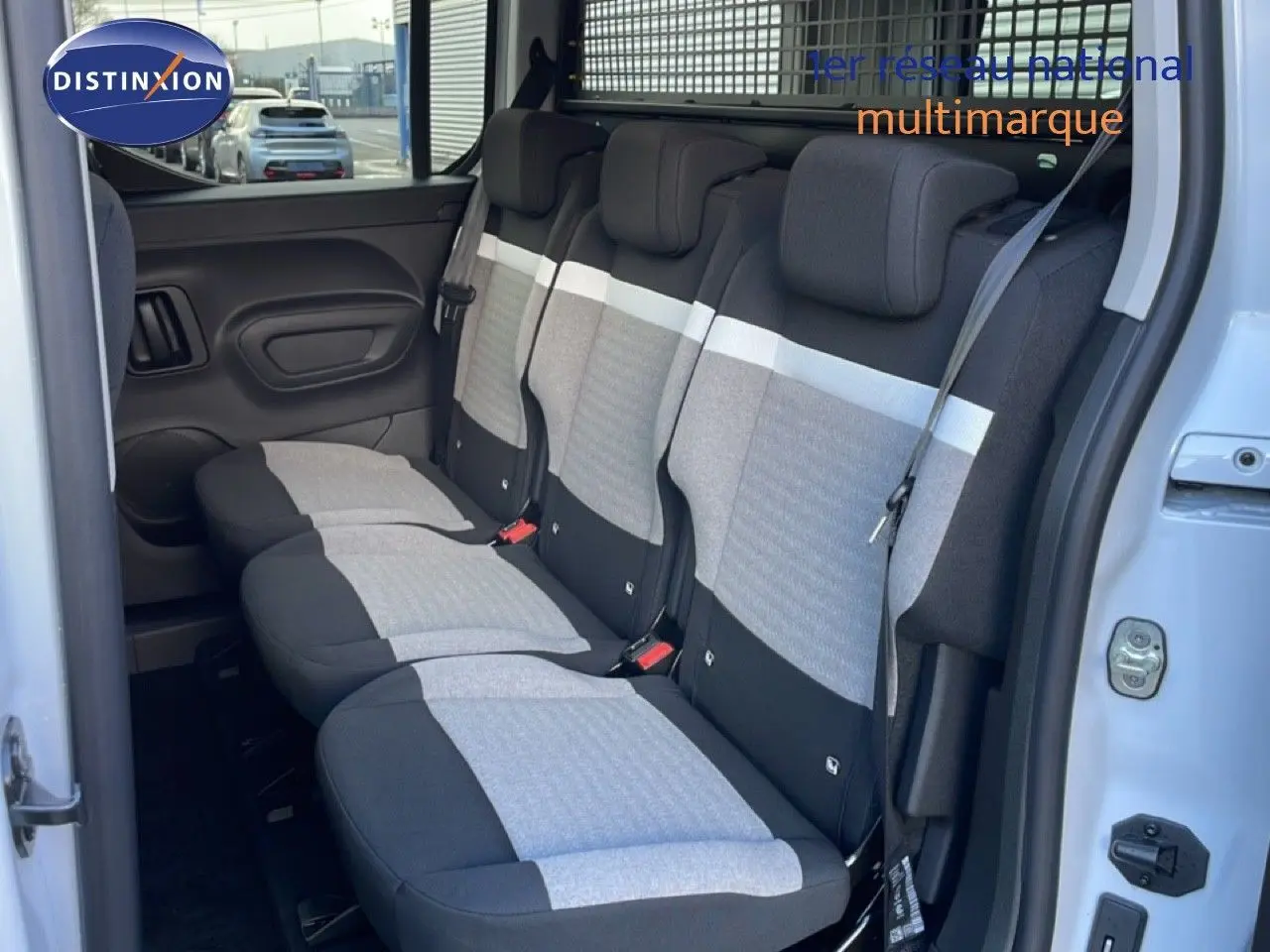 Vue intérieure montrant la banquette arrière en tissu gris et noir du Citroën Berlingo Multispace blanc glacier, porte ouverte côté droit.