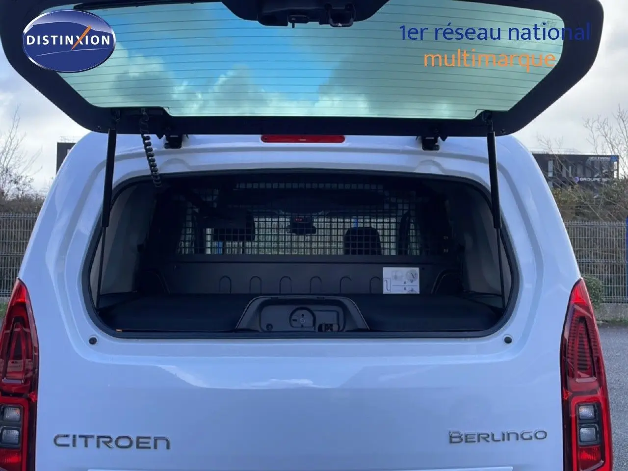 Vue arrière du Citroën Berlingo blanc glacier 2025 avec hayon ouvert, mettant en valeur le coffre spacieux et la grille de séparation.