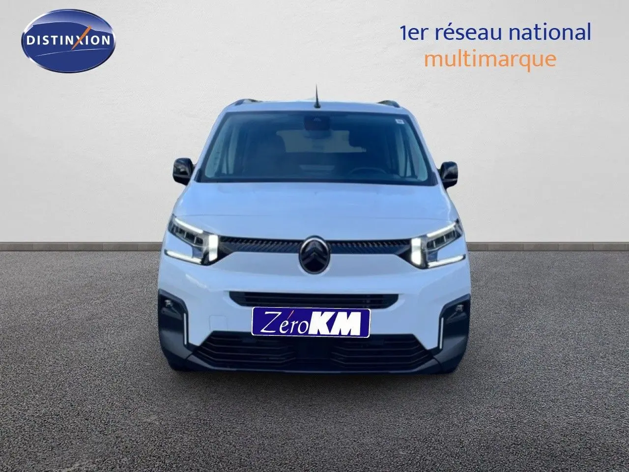 Vue frontale d'un Citroën Berlingo Multispace blanc glacier 2025 avec calandre noire et phares LED allumés.