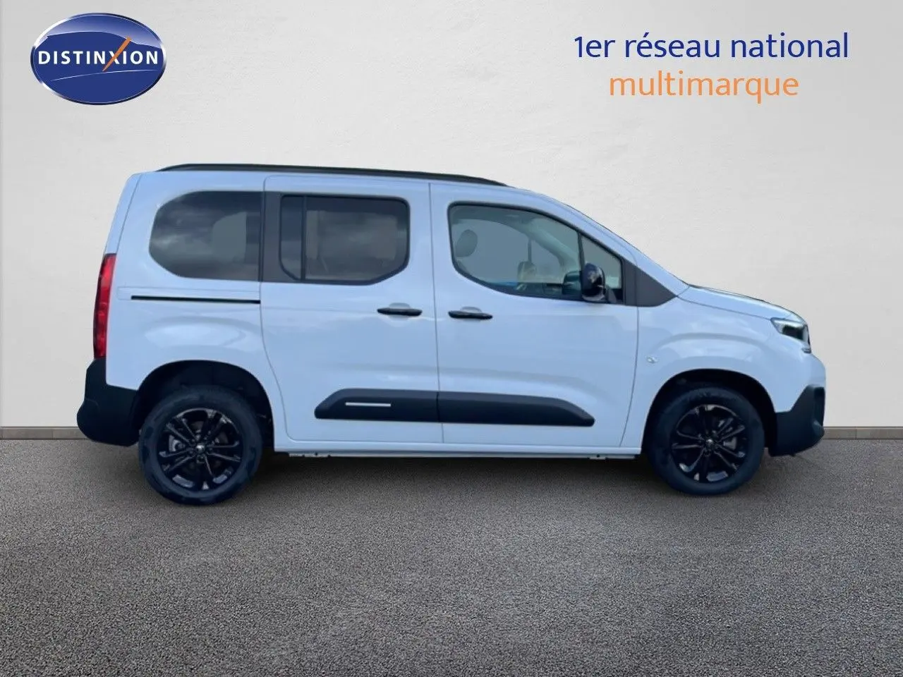 Profil droit d'un Citroën Berlingo blanc glacier avec jantes noires et protections latérales noires.