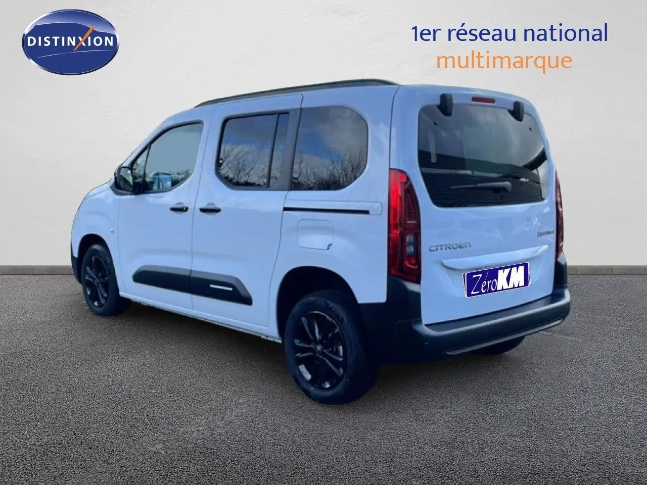 Vue 3/4 arrière droite d’un Citroën Berlingo Multispace blanc glacier avec vitres teintées et jantes noires.