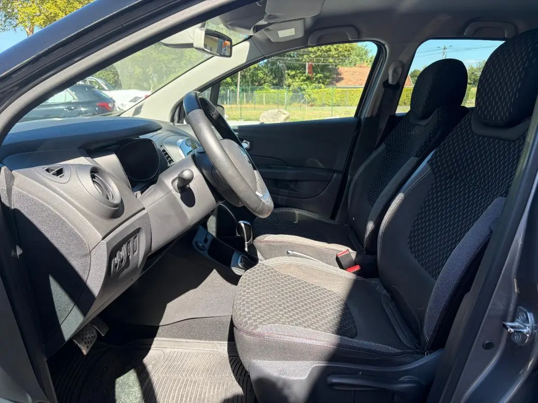 Vue intérieure côté conducteur du Renault Captur gris 2017, montrant sièges avant et tableau de bord.