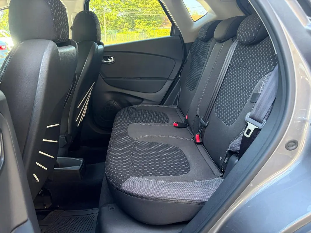 Vue intérieure côté droit des sièges arrière gris du Renault Captur 2017 avec banquette 1/3-2/3 et ceintures visibles.