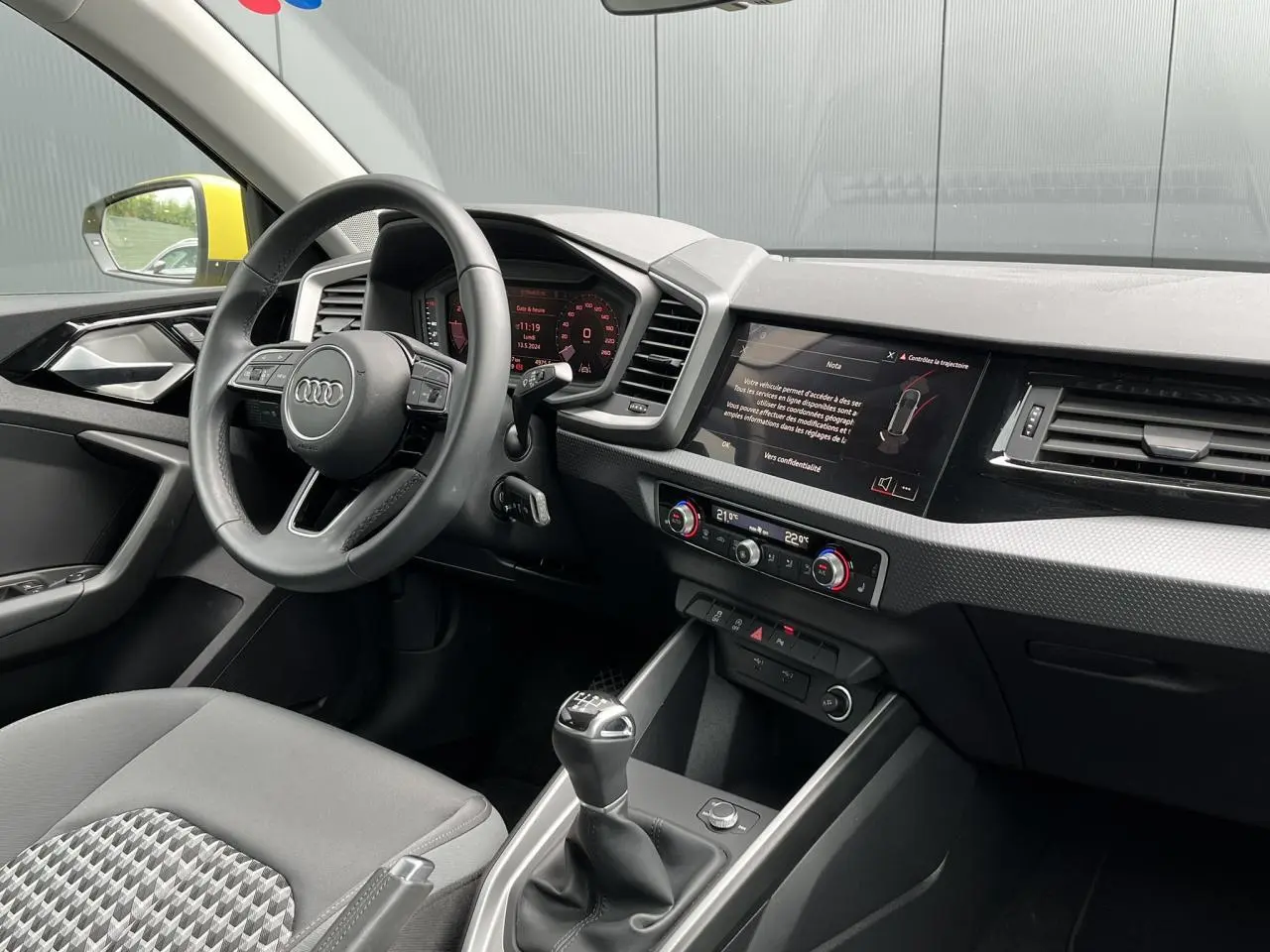 Intérieur Audi A1 Allstreet 2022 vu côté conducteur, volant cuir, écran tactile et levier de vitesse manuel.