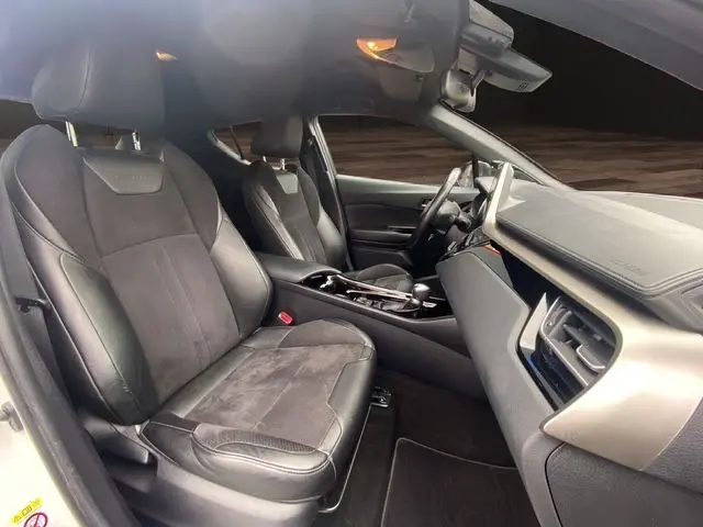 Intérieur avant du Toyota C-HR Hybride 2018, sièges cuir tissu noirs et tableau de bord moderne côté passager.