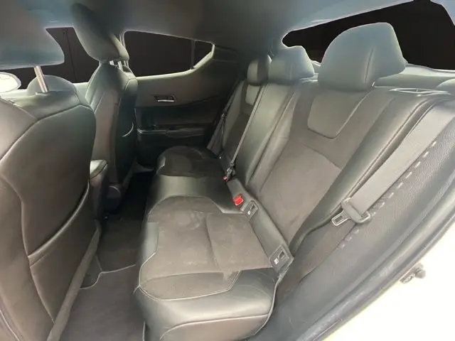 Vue intérieure côté droit montrant la banquette arrière en cuir et tissu noir du Toyota C-HR Hybride blanc toit noir 2018.