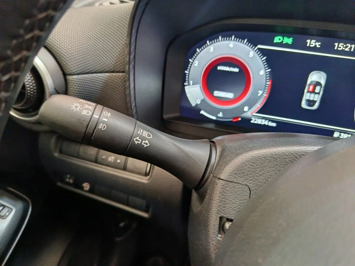 Gros plan sur la manette de clignotants et le combiné d'instruments numérique du Nissan Juke gris clair 2025.