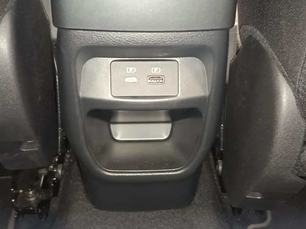Vue rapprochée des ports USB arrière noirs situés entre les sièges arrière du Nissan Juke gris clair 2025.