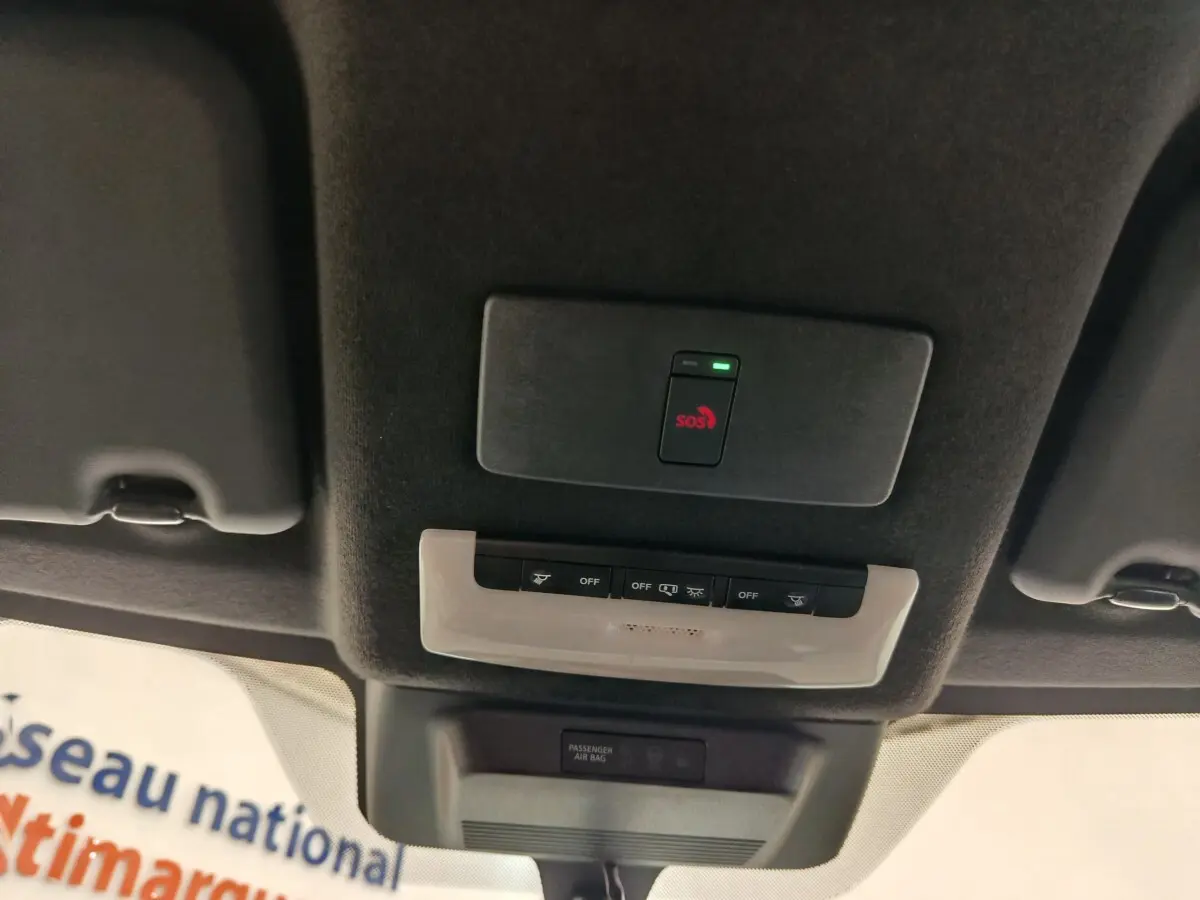 Vue intérieure du plafond du Nissan Juke 2025 avec bouton SOS rouge et commandes d'éclairage intégrées.
