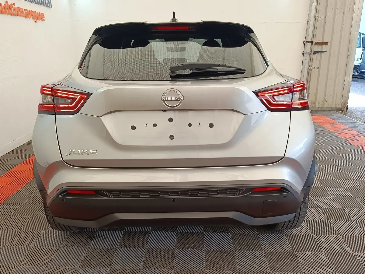Vue arrière d'un Nissan Juke gris clair 2025 avec feux LED et logo Nissan bien visibles.