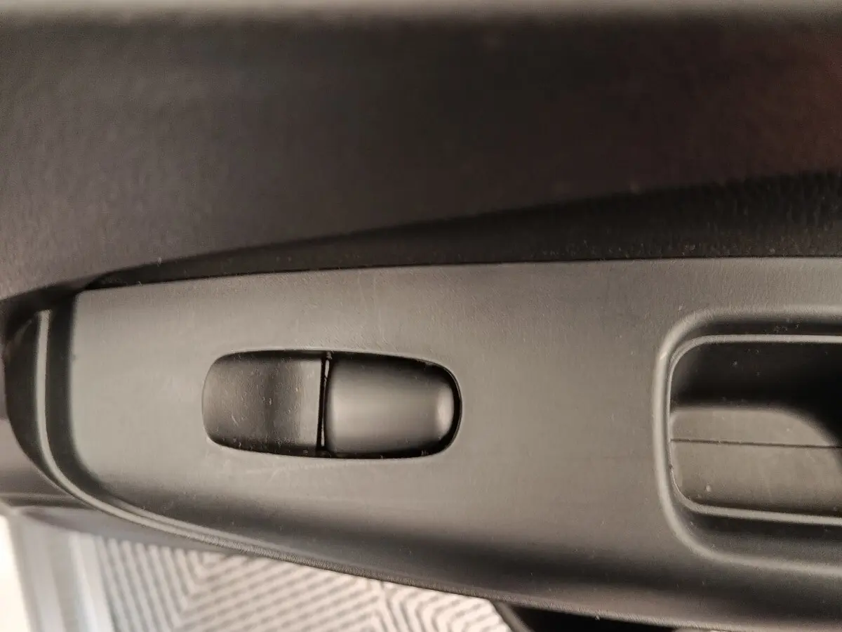 Gros plan sur la commande de réglage électrique du siège côté conducteur du Nissan Juke gris clair 2025.
