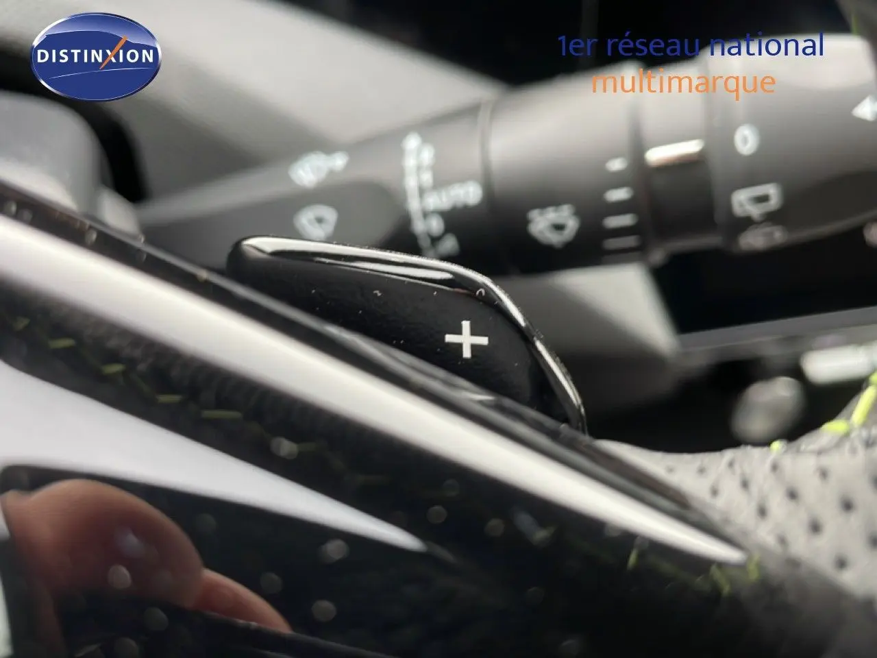 Gros plan sur la palette de changement de vitesse "+" du volant d'une Peugeot 308 gris selenium, intérieur noir.