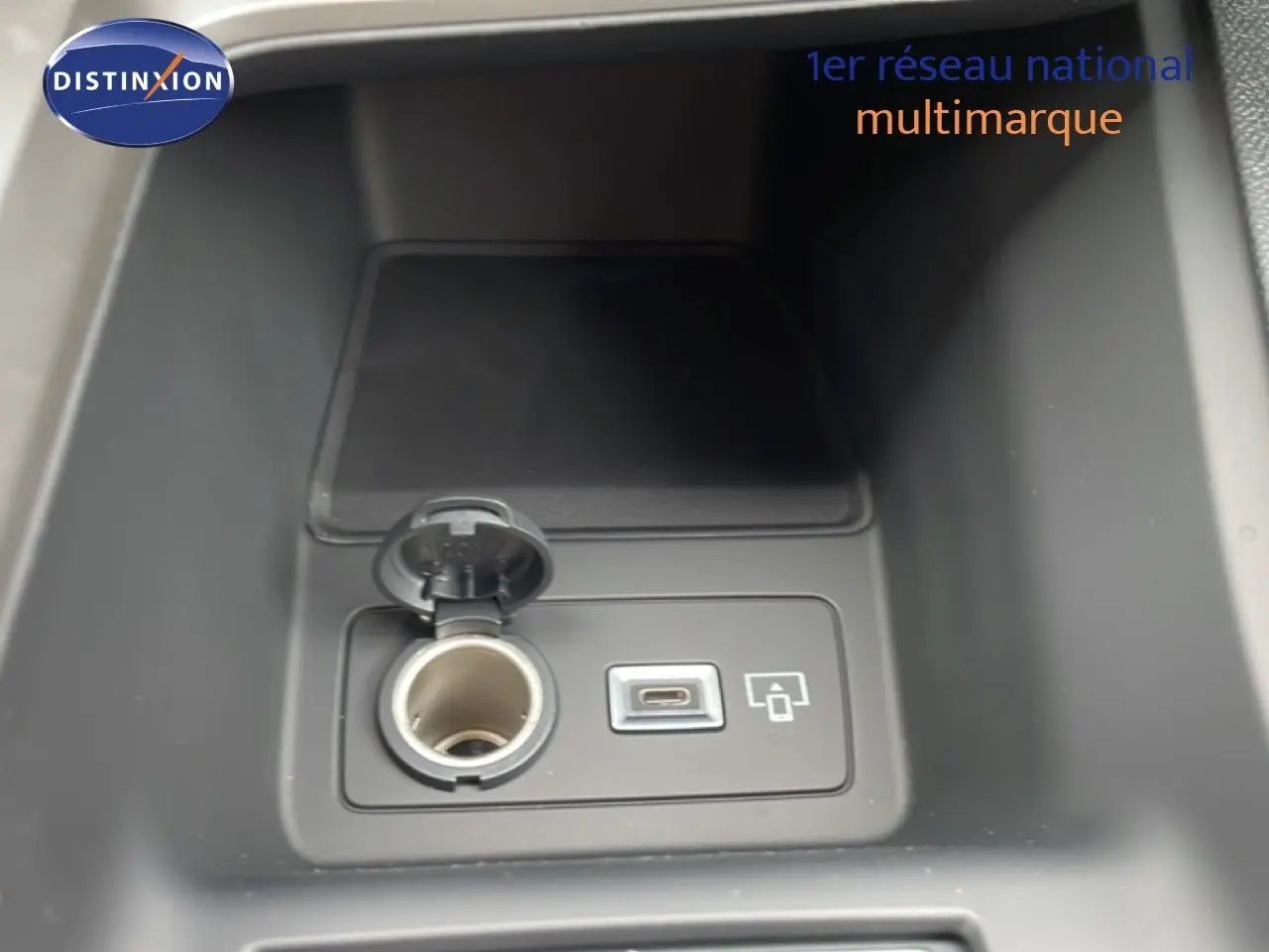 Prise allume-cigare et port USB-C visibles dans la console centrale d’une Peugeot 308 gris selenium hybride.
