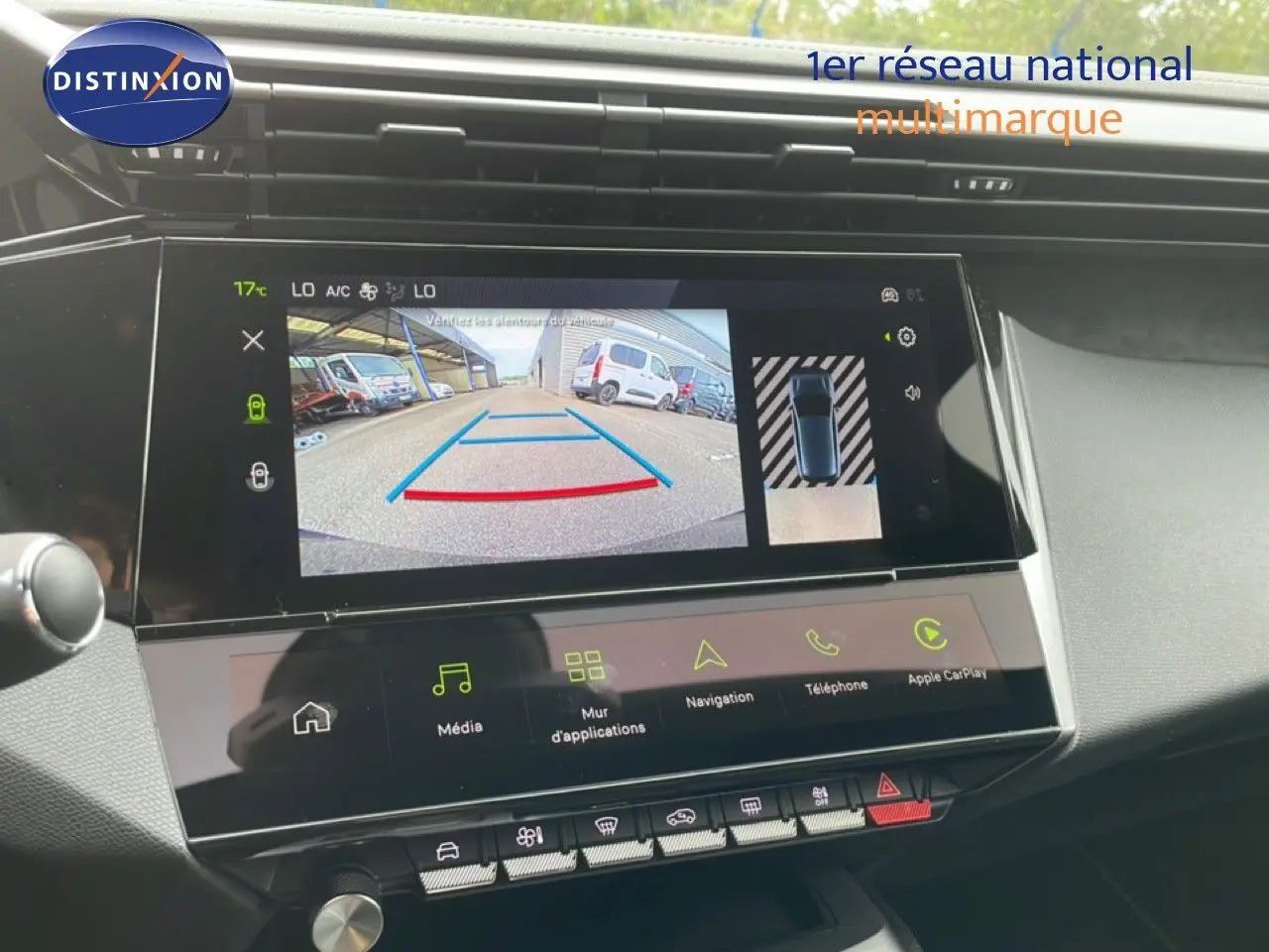 Vue intérieure du tableau de bord de la Peugeot 308 hybride 2026, écran tactile affichant la caméra de recul et les commandes multimédia.