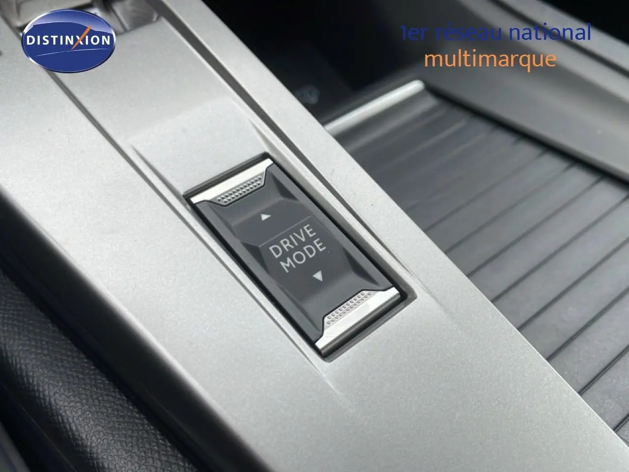 Gros plan sur le bouton Drive Mode au centre de la console intérieure d’une Peugeot 308 gris selenium metal.