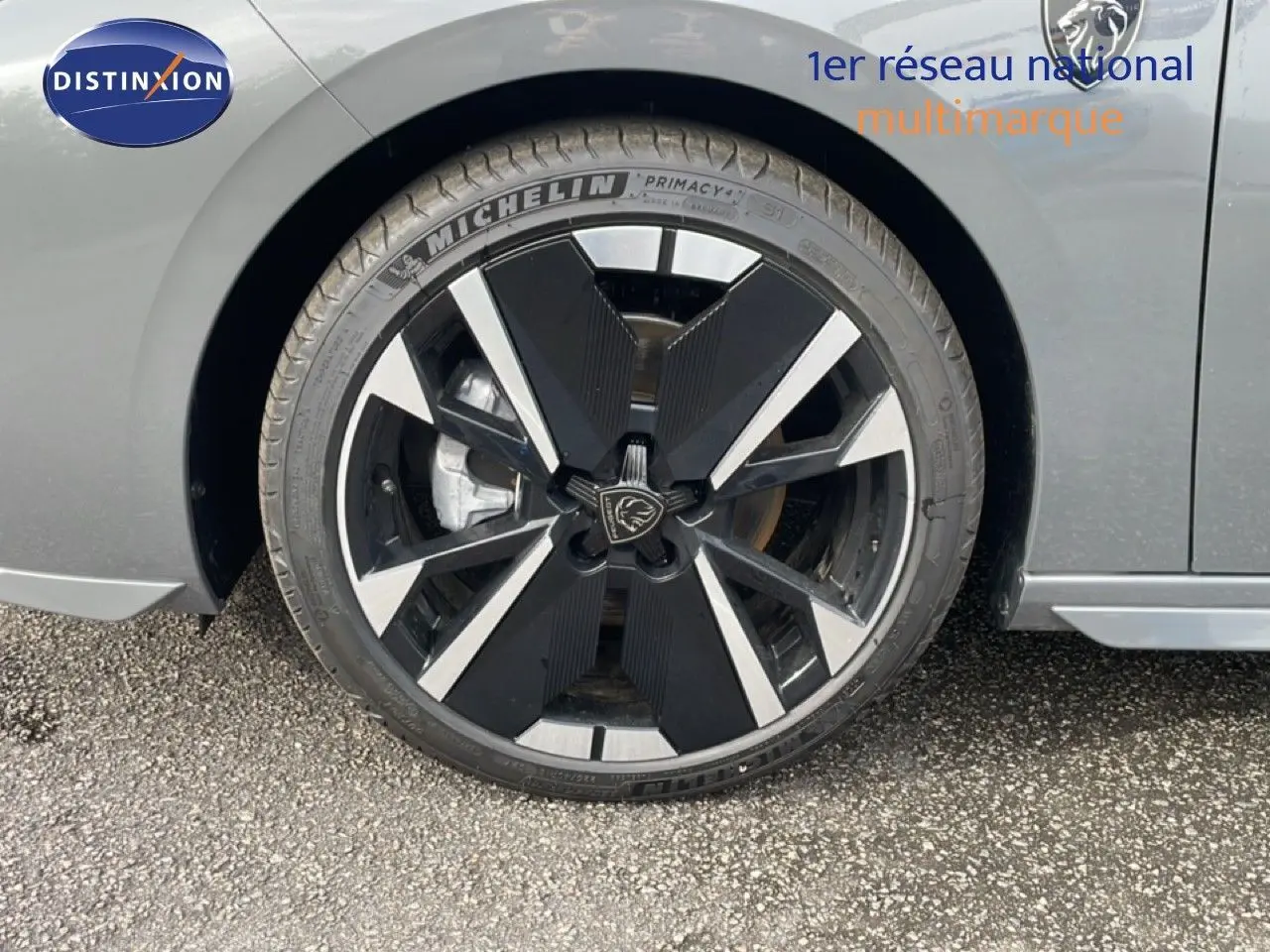 Gros plan sur la roue avant droite d’une Peugeot 308 gris selenium metal avec jante noire et argentée au design moderne.