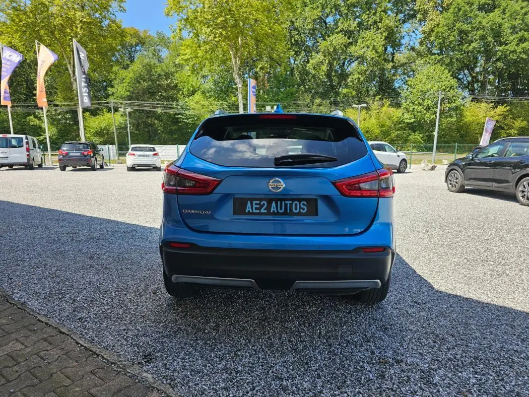 Vue arrière d'un Nissan Qashqai bleu 2019, avec feux arrière distinctifs et plaque AE2 AUTOS visible.