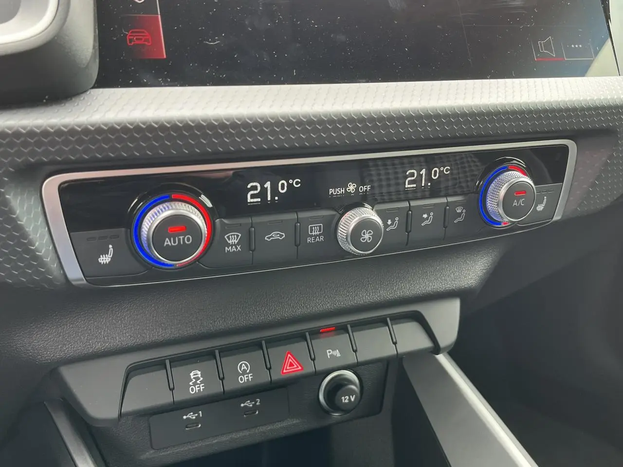 Gros plan sur la console centrale de l'Audi A1 Sportback 25 TFSI 2022 montrant la climatisation automatique bi-zone et les commandes.