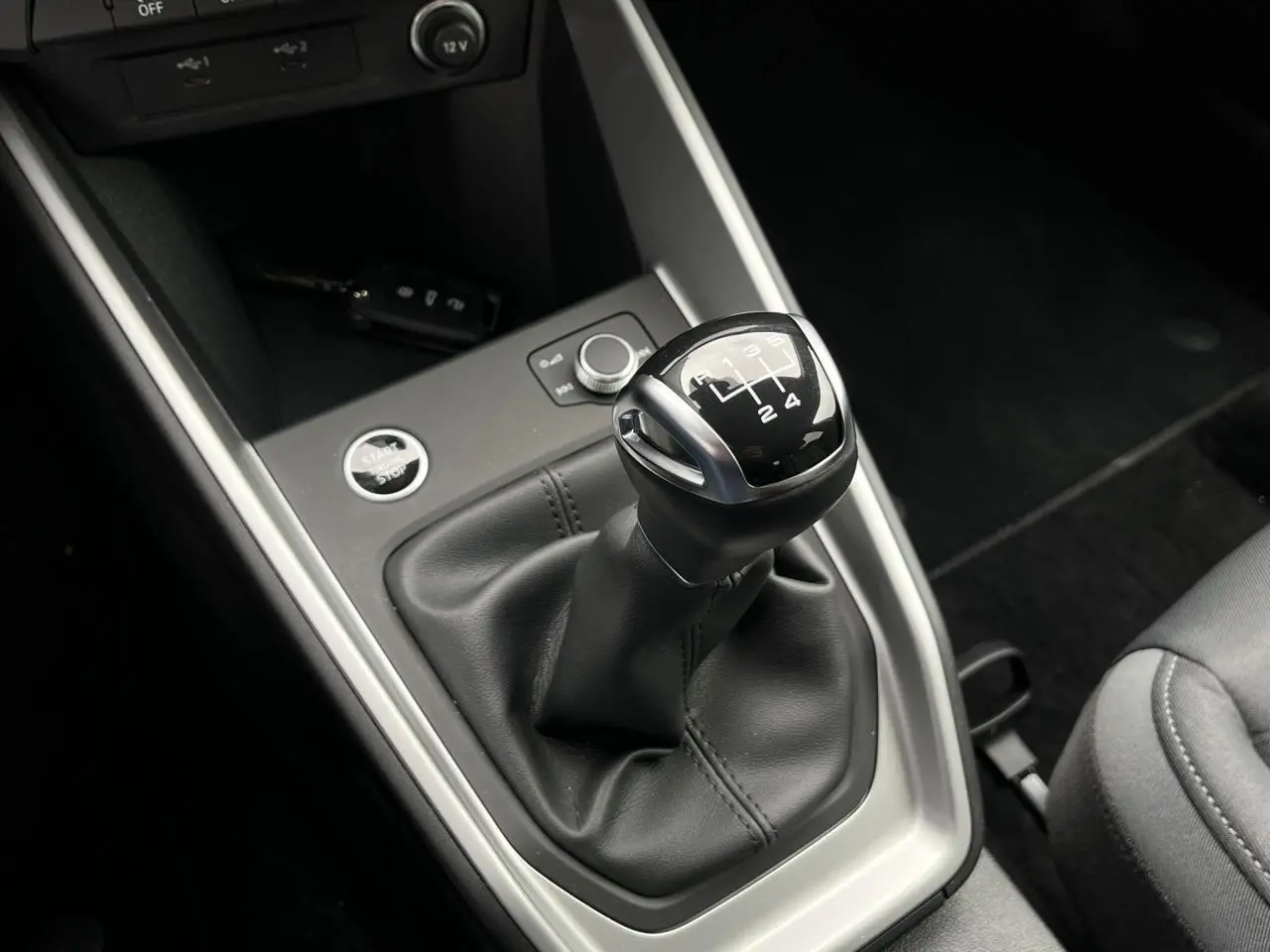 Le levier de vitesses manuel noir de l'Audi A1 Sportback 25 TFSI Advanced vu de dessus avec la clé mains libres à proximité.