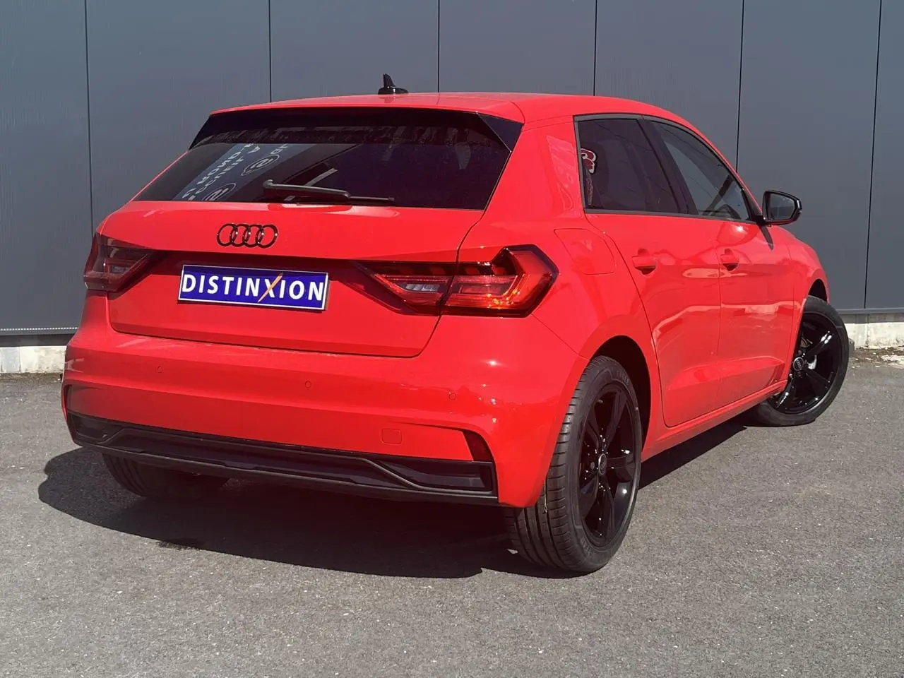Audi A1 Sportback rouge Misano vue 3/4 arrière droit avec jantes noires et vitres surteintées.