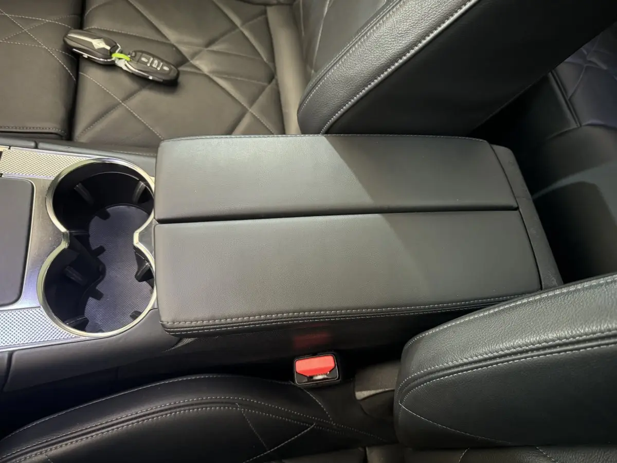 Gros plan sur la console centrale en cuir noir du DS7 Crossback E-TENSE 4x4 avec clé posée sur le siège côté droit.