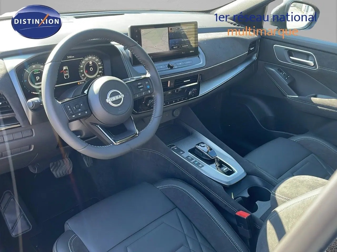 Intérieur du Nissan Qashqai 2025 vu côté conducteur, tableau de bord moderne avec écran tactile et sellerie noire cuir et alcantara.