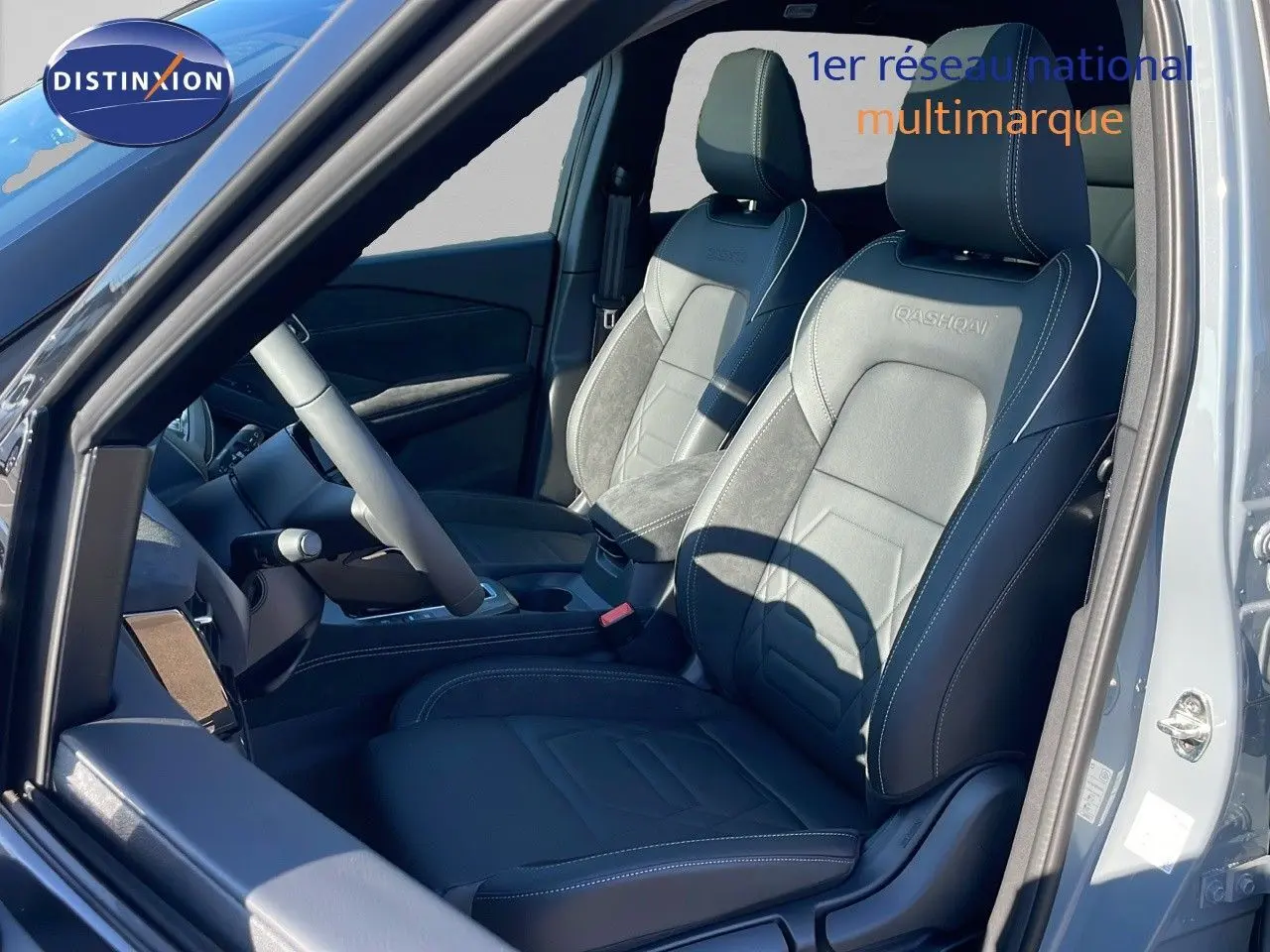 Vue intérieure côté gauche du Nissan Qashqai 2025, sièges en cuir noir avec surpiqûres blanches et logo Qashqai brodé.