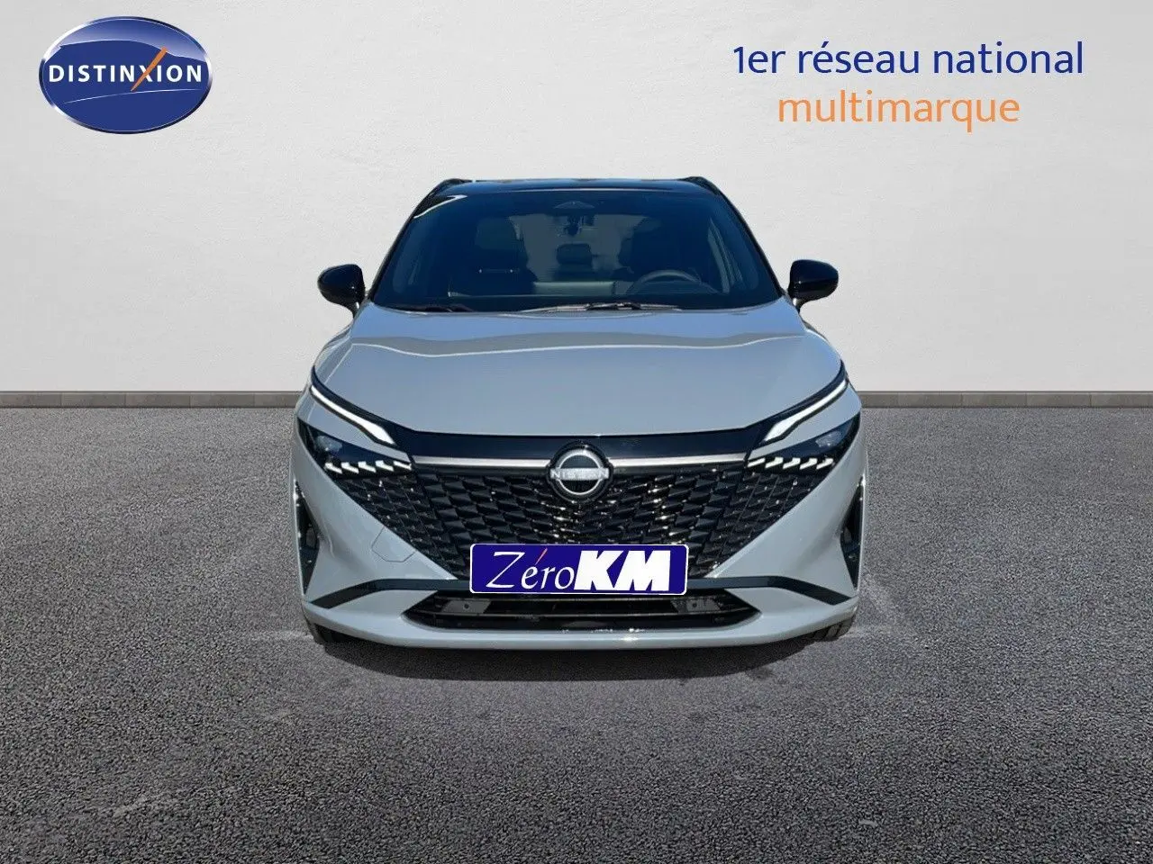 Vue frontale d'un Nissan Qashqai 2025 gris céramique avec toit noir, calandre noire et phares LED fins.