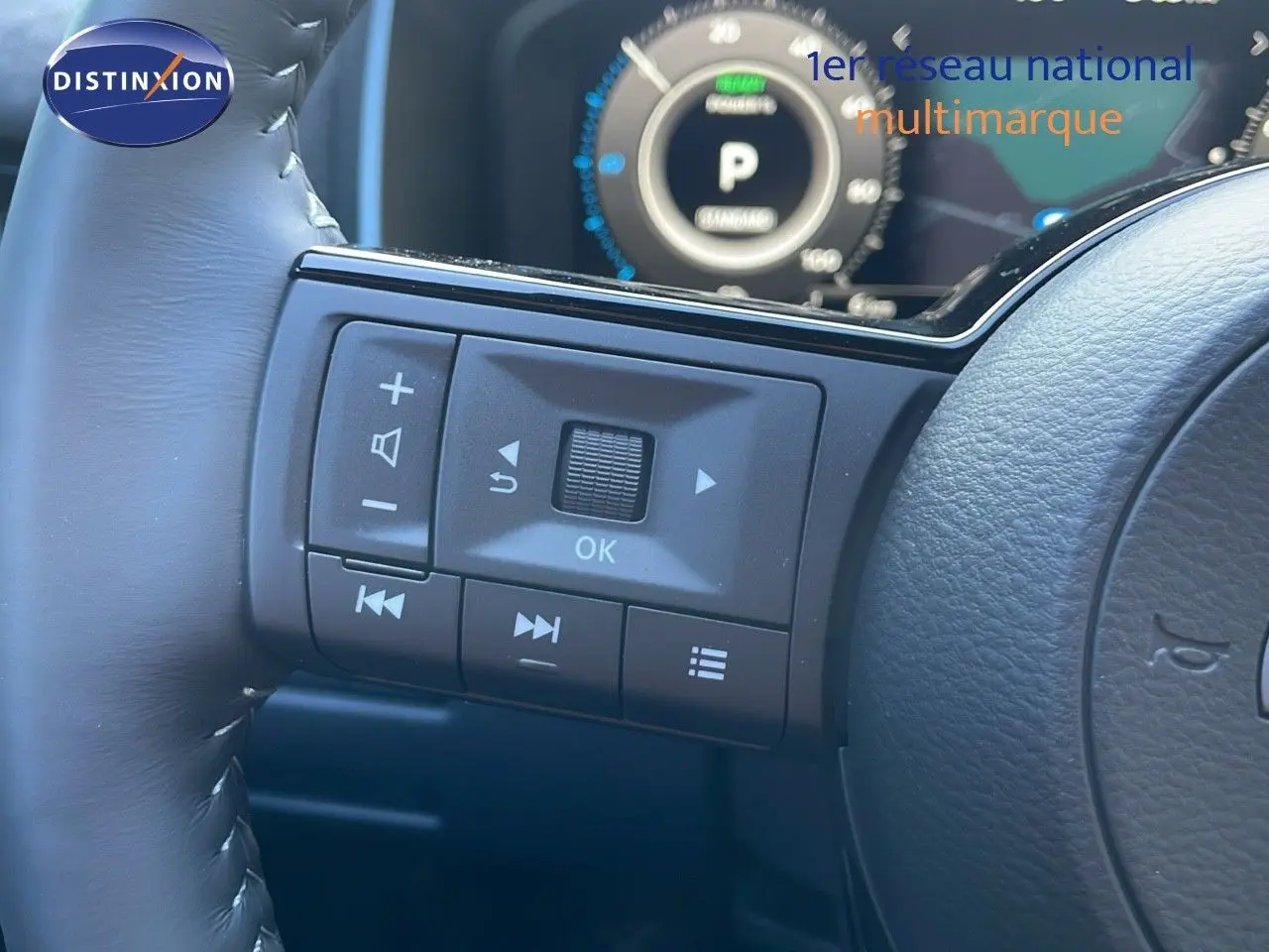 Vue rapprochée des commandes au volant à gauche du Nissan Qashqai 2025 gris céramique avec toit noir.