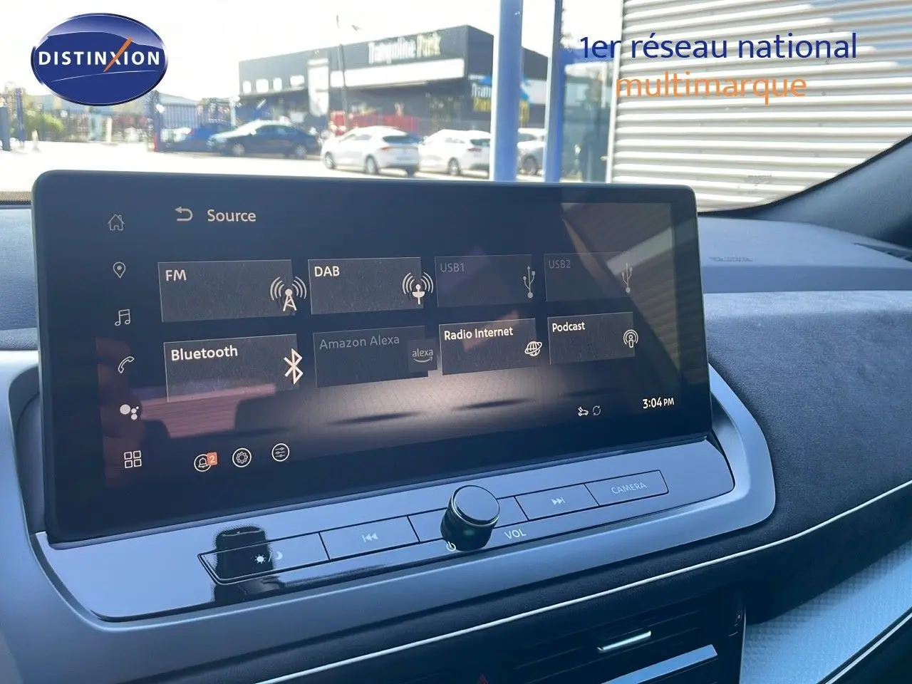 Écran tactile central du Nissan Qashqai 2025, affichant les options multimédia avec tableau de bord noir et gris.