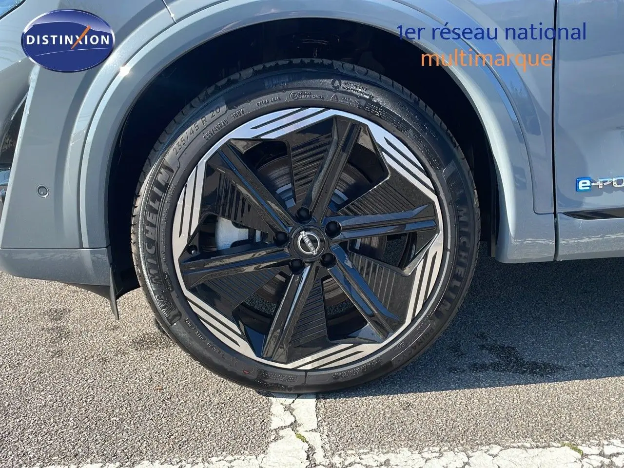 Gros plan sur la roue avant gauche du Nissan Qashqai gris céramique avec jante noire et grise au design moderne.