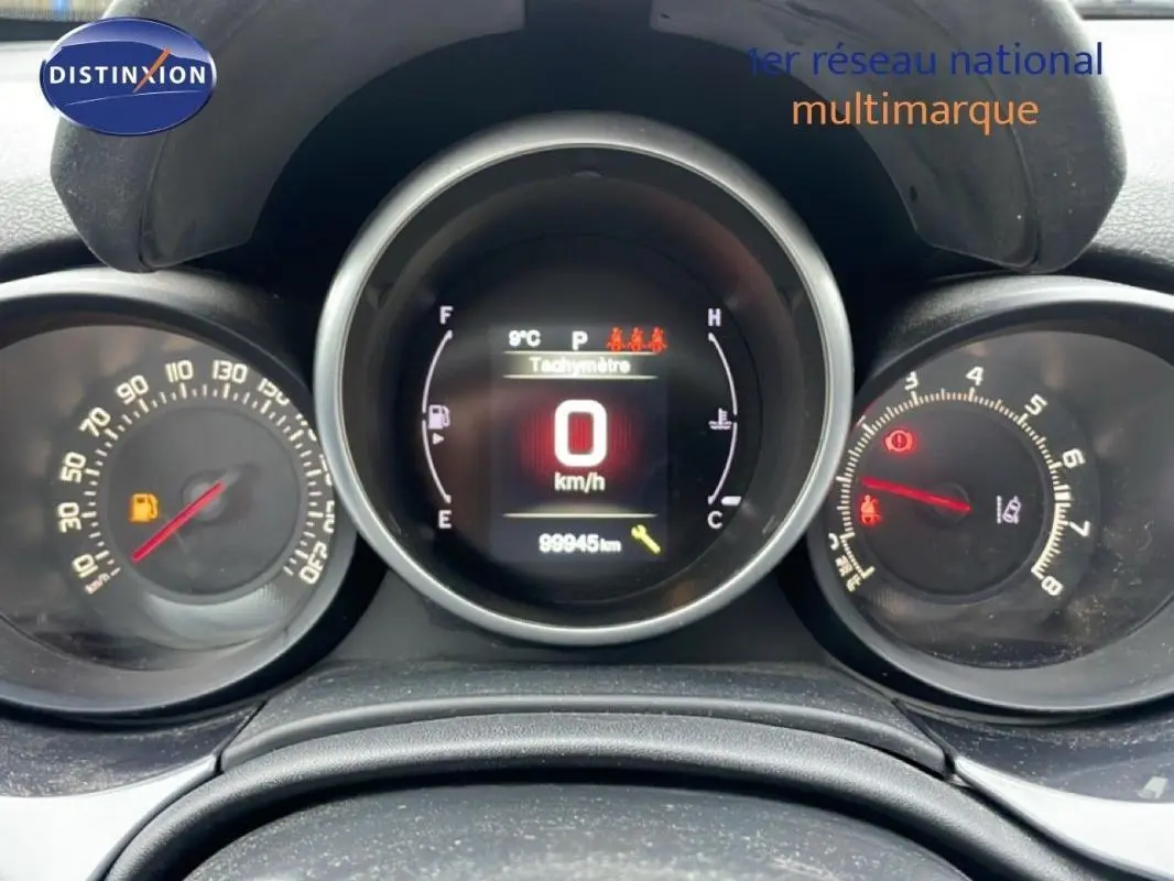 Tableau de bord de Fiat 500X gris foncé, affichage numérique à 0 km/h avec compte-tours et jauge carburant visibles.