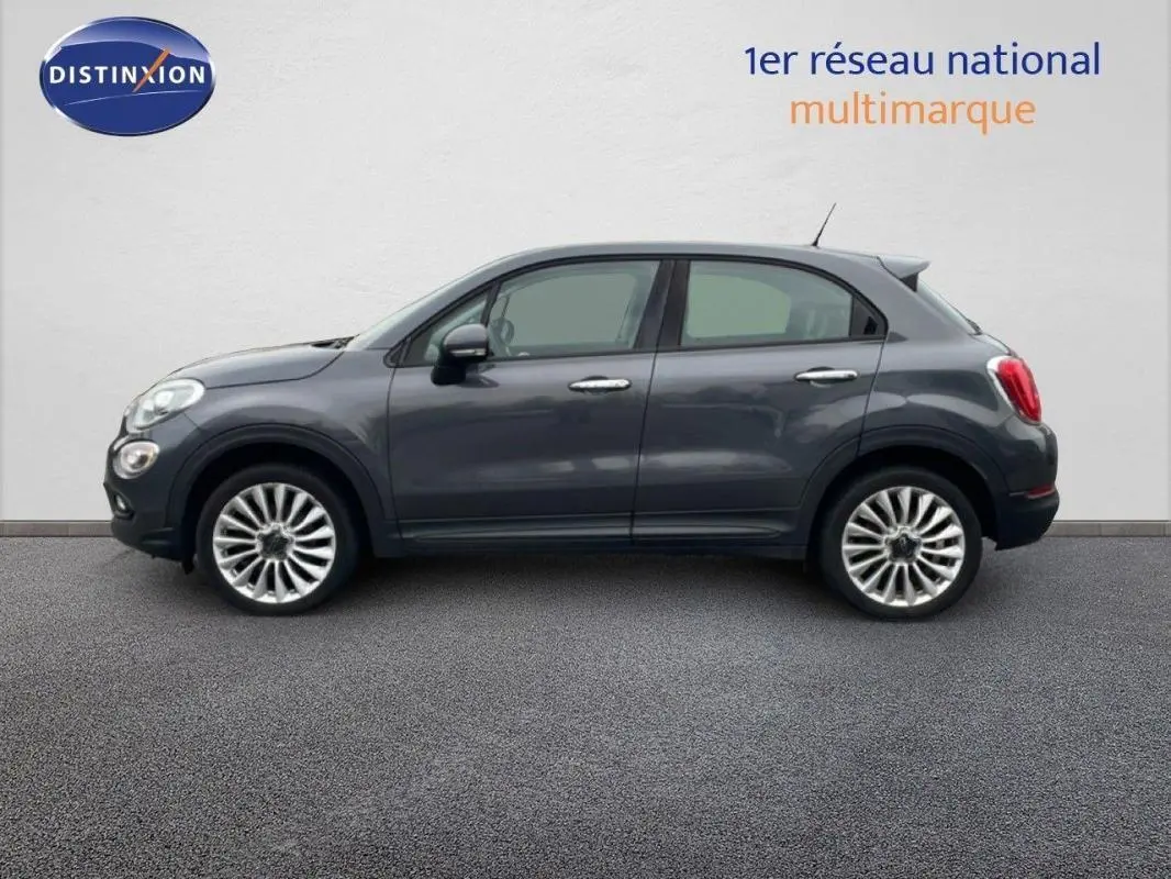 Profil latéral droit d'une FIAT 500X gris foncé avec jantes alliage 18 pouces sur fond neutre.