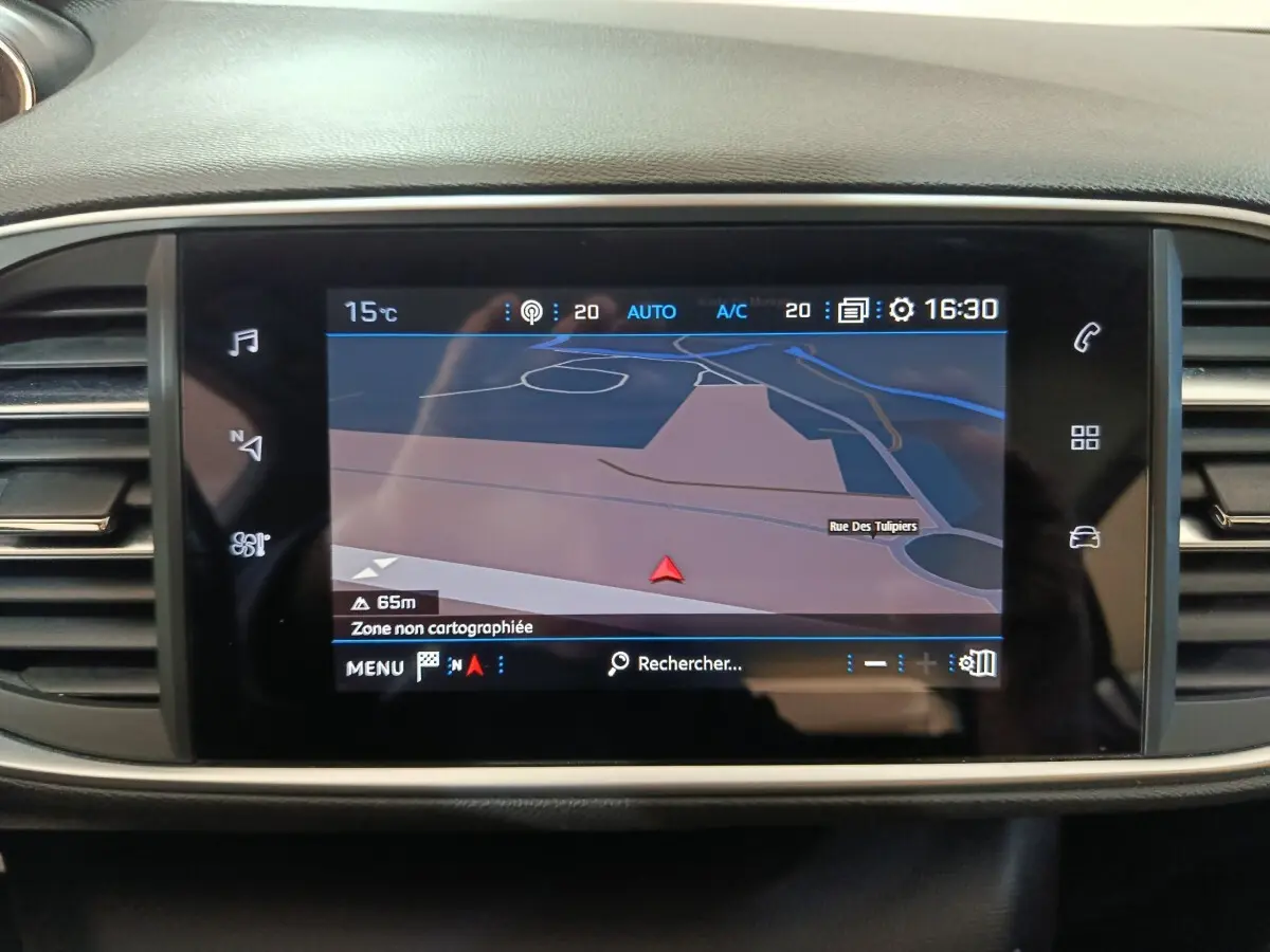 Écran tactile central du tableau de bord de la Peugeot 308 blanc, affichant la navigation GPS en mode carte.