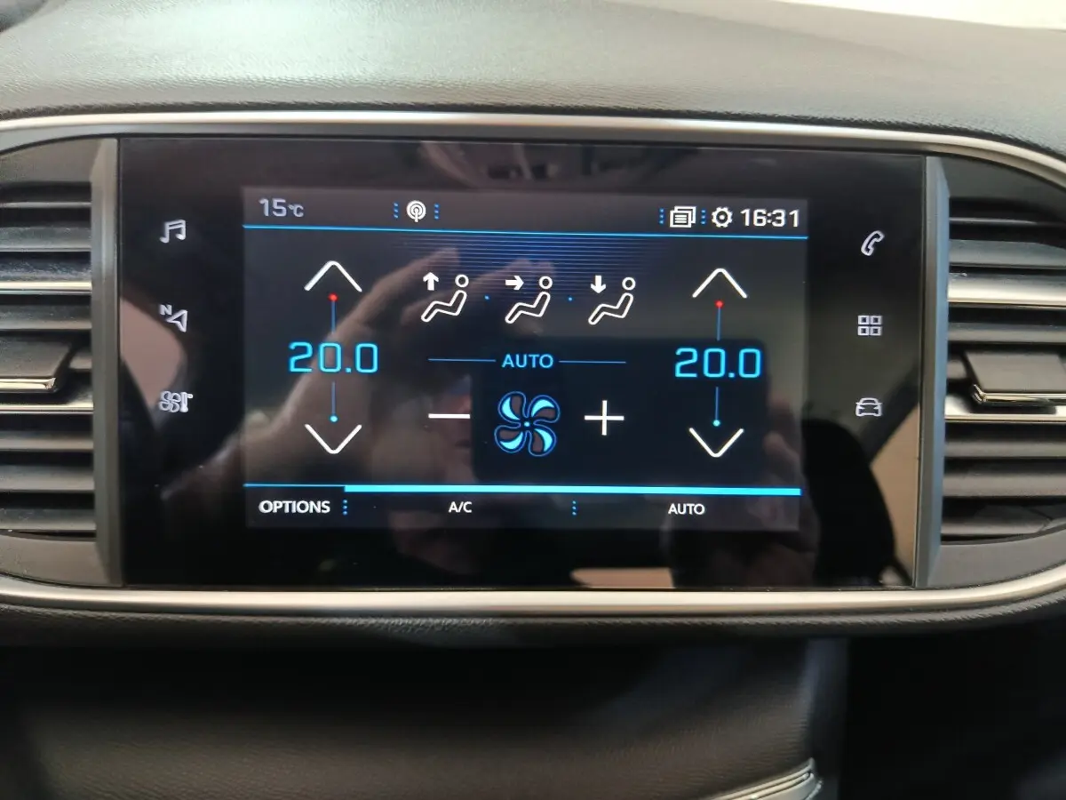 Écran tactile central de la climatisation bi-zone affichant 20°C dans une Peugeot 308 blanche de 2021.
