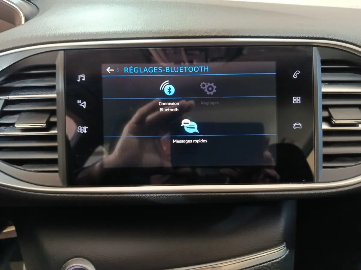 Écran tactile central affichant les réglages Bluetooth du Peugeot 308 blanc, vue frontale intérieure du tableau de bord.