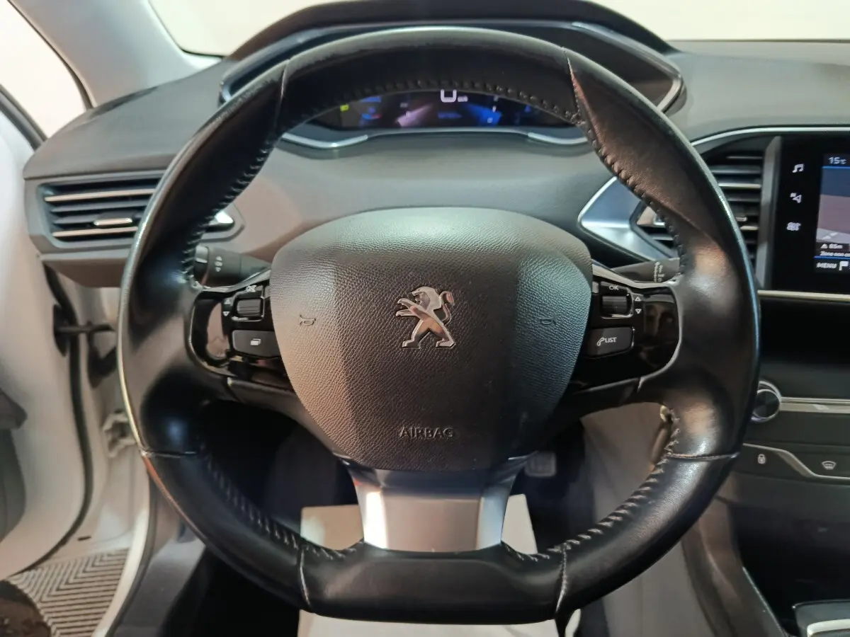 Volant cuir noir de Peugeot 308 BlueHDi 130 S&S Premium Pack 2021 avec tableau de bord et écran tactile visible.