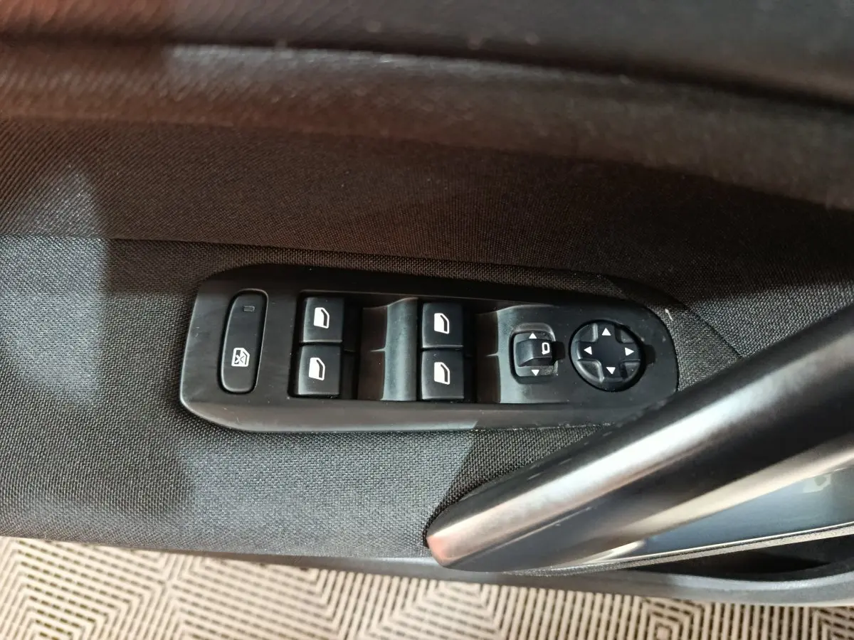 Commande des vitres et réglage des rétroviseurs sur la porte côté conducteur d'une Peugeot 308 blanche 2021