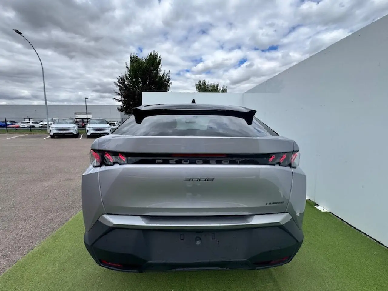 Vue arrière d’un Peugeot 3008 gris Artense avec toit noir, feux arrière à griffes LED et bandeau noir laqué.
