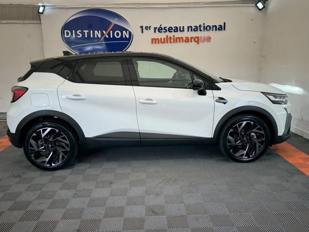 Profil côté gauche du Renault Captur blanc esprit Alpine E-Tech 145 hybride, avec toit noir et jantes noires stylisées.
