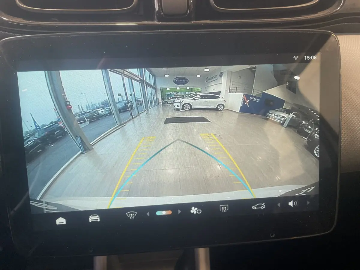 Vue caméra de recul sur l'écran tactile du tableau de bord, montrant l'arrière blanc du Leapmotor T03 Luxury en intérieur showroom.